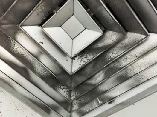 Dirty air vent cover with heavy dust and debris buildup before professional duct cleaning service.